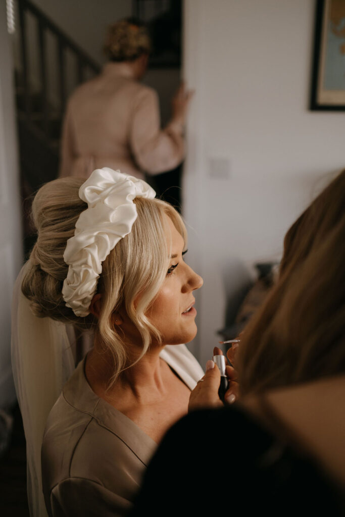 Side profile of a bride getting her makeup done